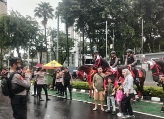 Gerimis Tak Surutkan Minat Warga Berpose Dengan Polisi Berkuda