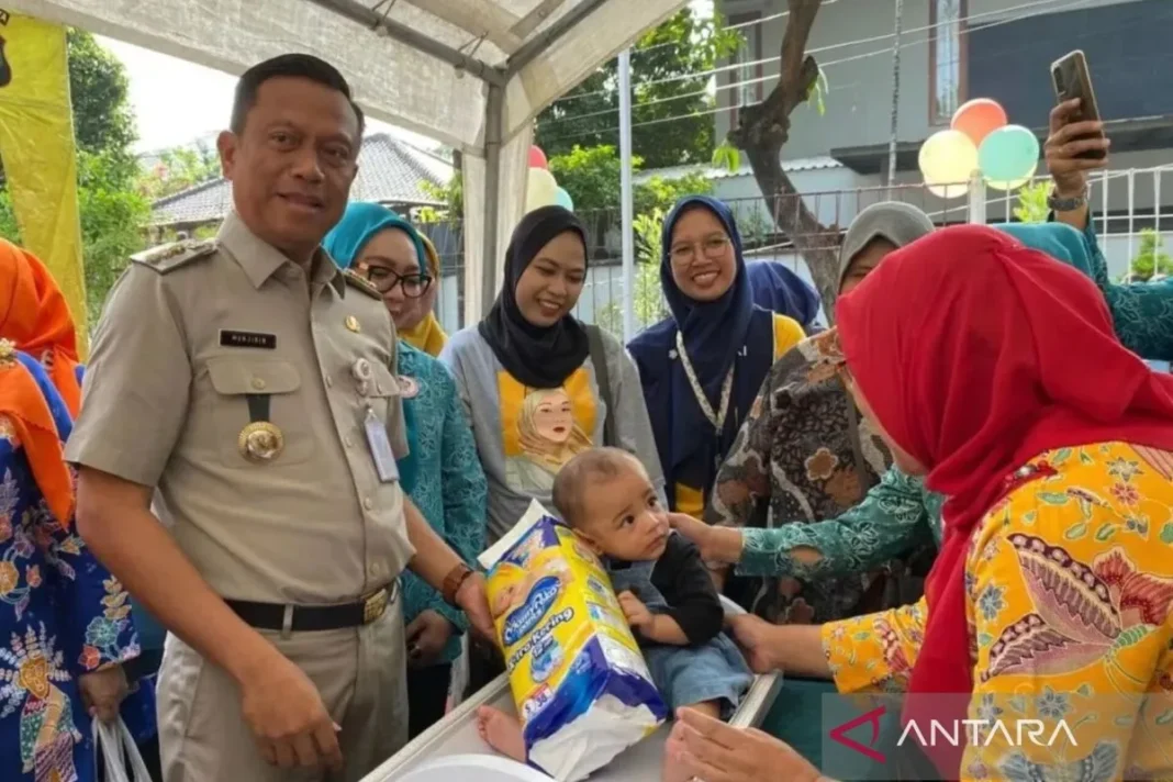 Wali Kota Administrasi Jakarta Selatan Munjirin membagikan popok kepada anak di RPTRA Tunas Muda, Jakarta, Jumat